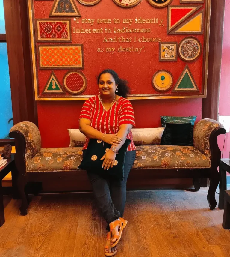 Merin George, a fashion designer in Kochi, is sitting on a sofa and smiling
