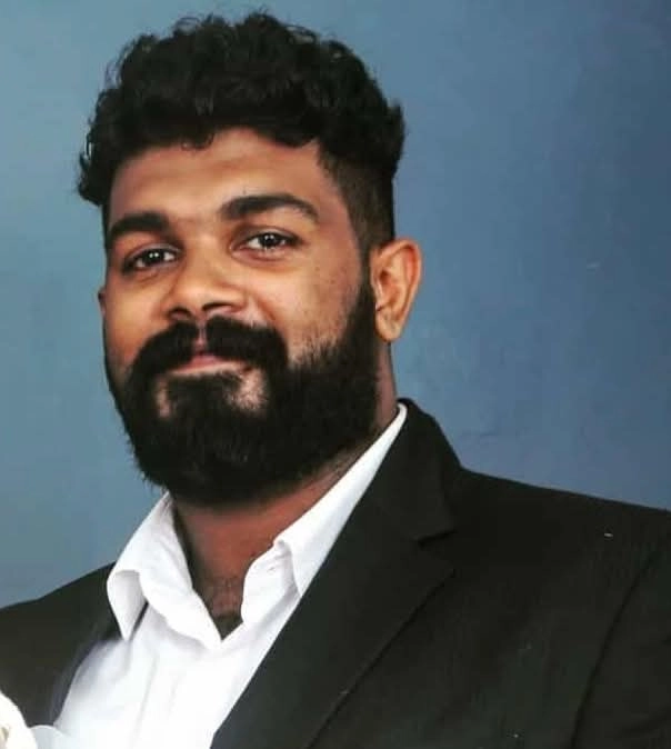a man with beard and moustache wearing suits and smiling