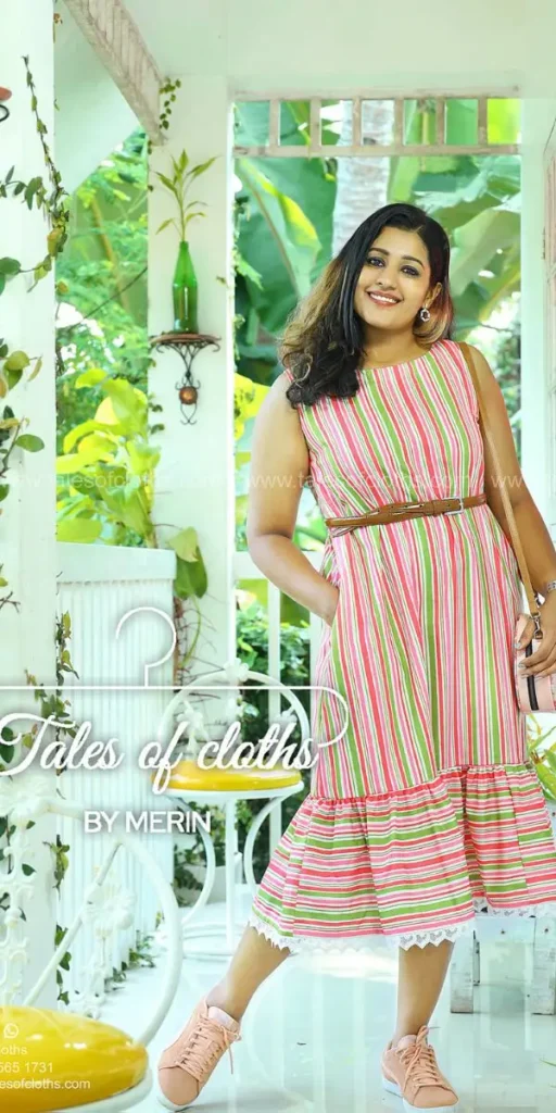 model smiles and poses in striped dress made by fashion designer in kochi