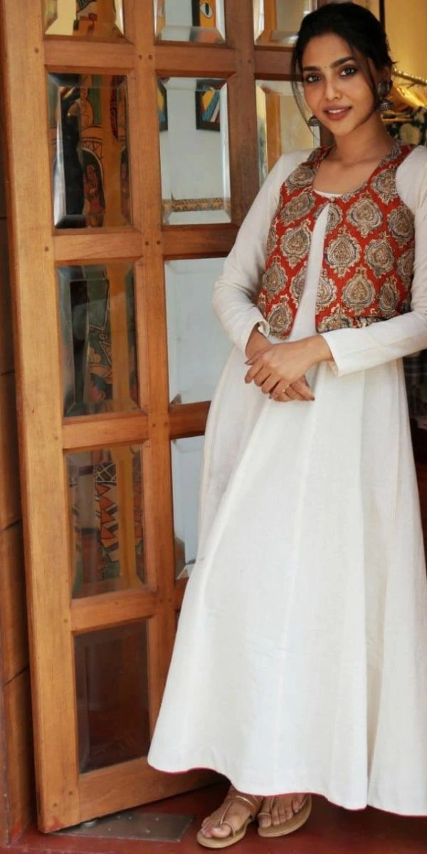 actress smiling and standing wearing an anarkali made by a fashion designer in Kochi.